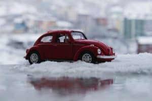 Red VW Bug in snow showing how rust can begin to form around your windshield