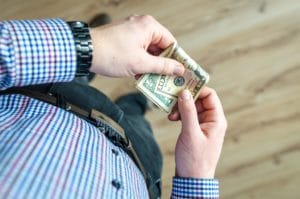 man looking down at money